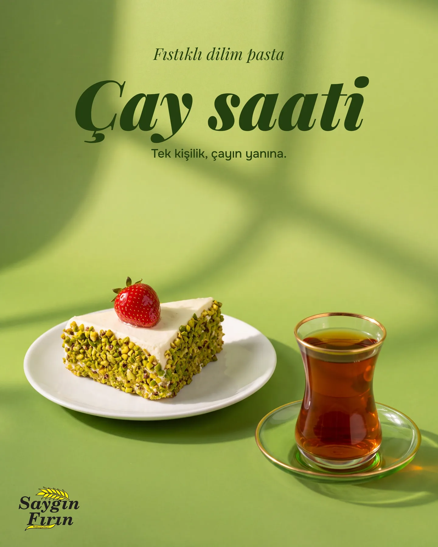 Saygın Fırın tek kart — "Çay saati", fıstık yeşili zeminde fıstıklı dilim pasta ve ince belli bardakta çay